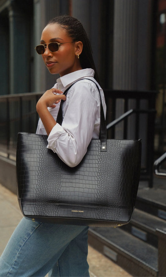 Black croc-texture vegan leather tote bag for work or travel, styled with white shirt and jeans