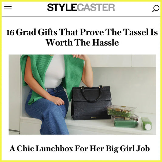 Woman with insulated black lunch tote, salad containers, and drinks on countertop