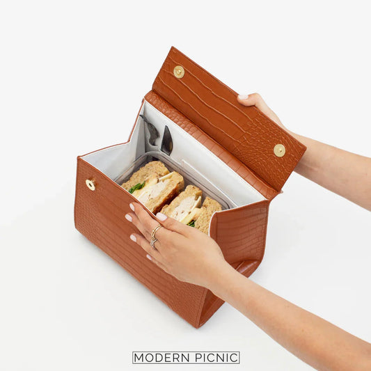 Brown insulated vegan leather lunch bag with sandwiches and utensils inside