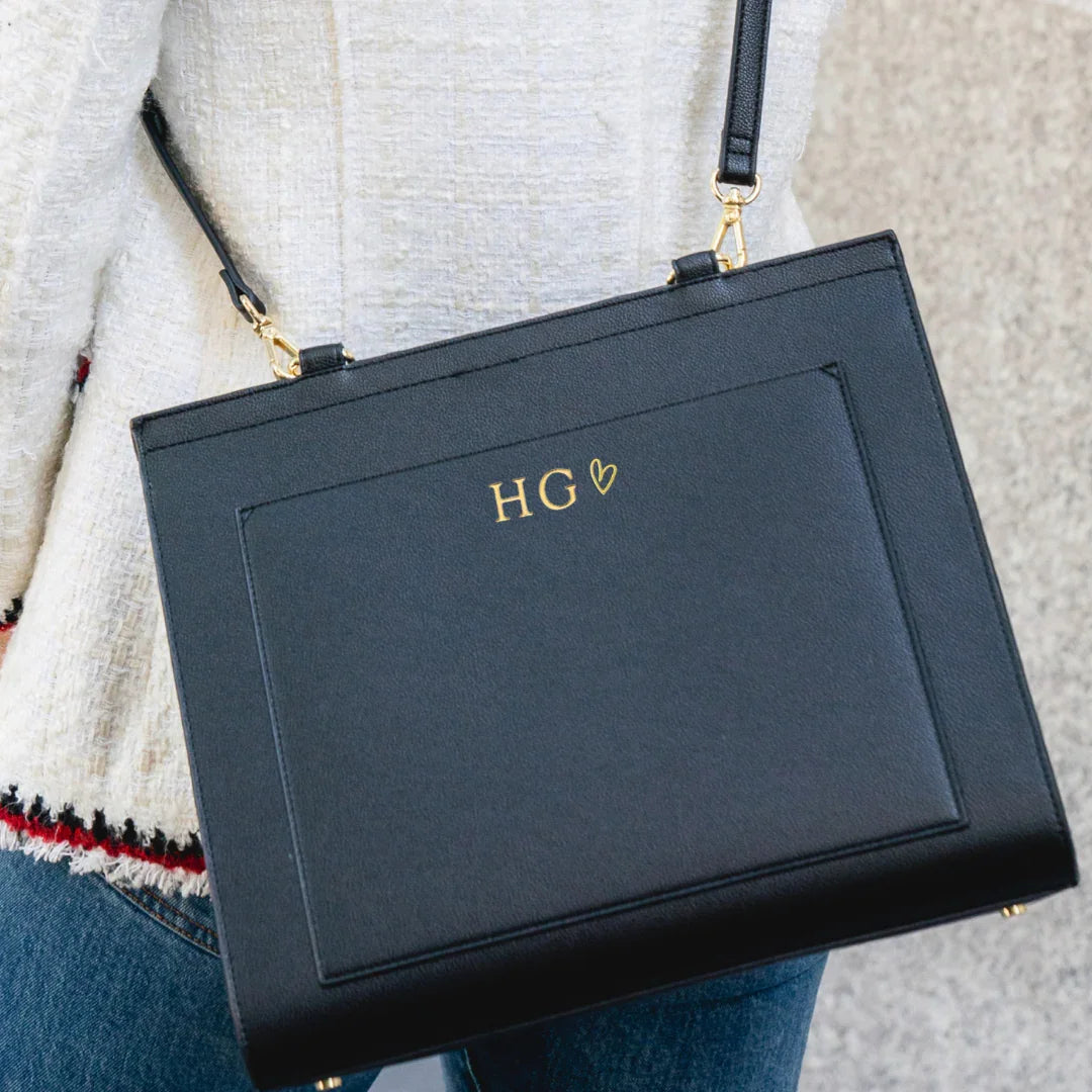 Black vegan leather lunch tote with gold initials, worn crossbody, chic and professional style