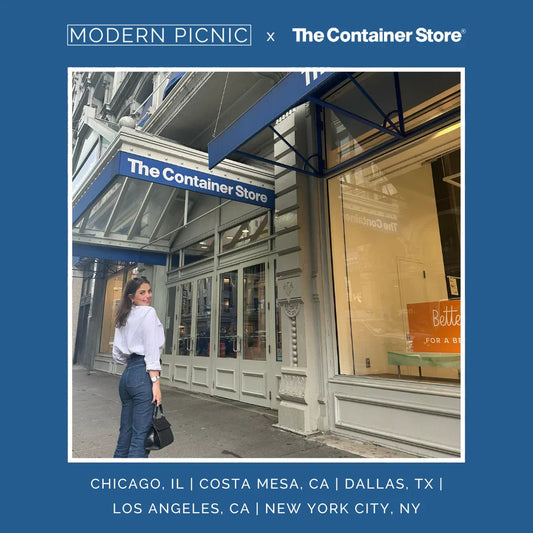 Woman with a black handbag outside The Container Store, city street, promotional signage.