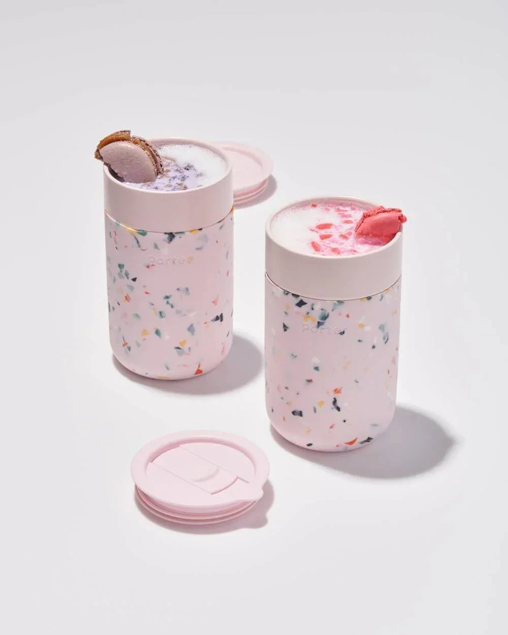 Pink speckled insulated drink tumblers with macarons, perfect for stylish on-the-go refreshments
