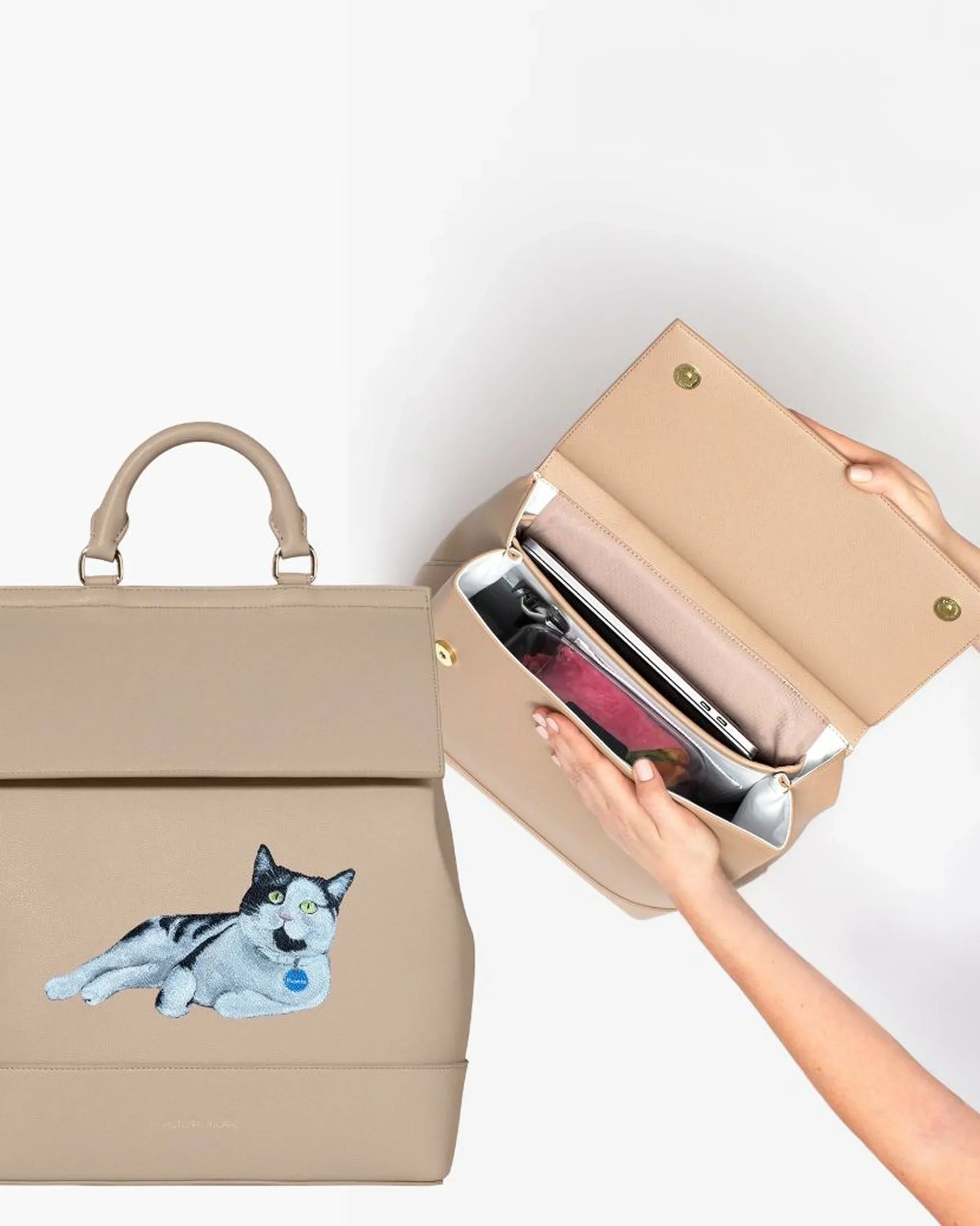 Beige insulated lunch tote with embroidered cat design, open to show organized interior compartments
