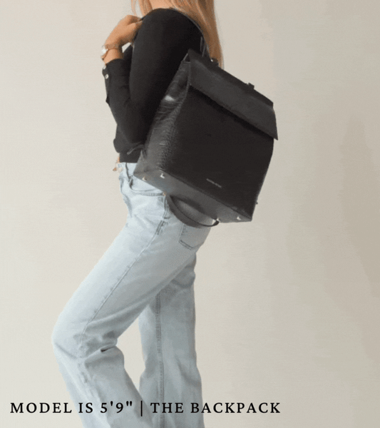 A video featuring lifestyle clips of a woman wearing a black long sleeve shirt, light wash jeans, and a Modern Picnic Black Croc Backpack