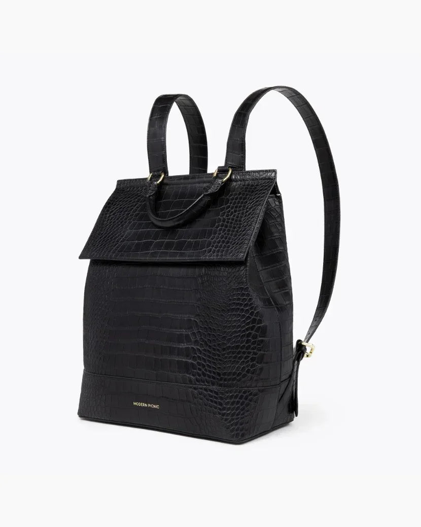 Angled view of the black crocodile-embossed insulated backpack with adjustable shoulder straps and top carry handle on a white background.