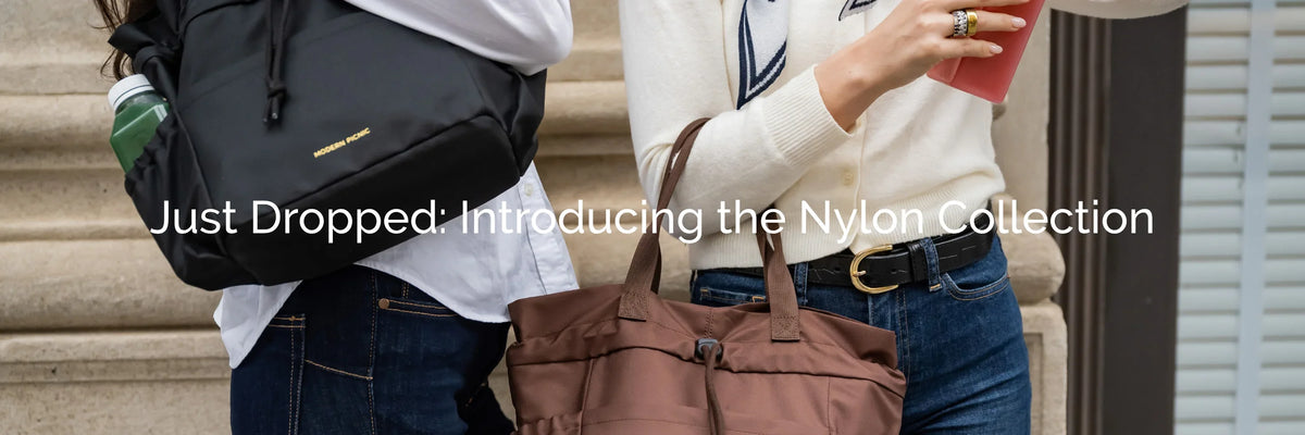 Two people carrying black and brown nylon backpacks and totes from the Nylon Collection.