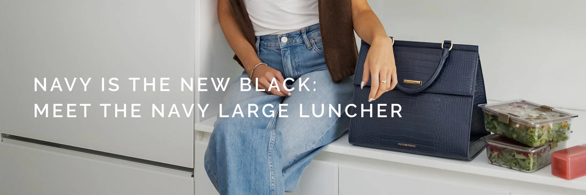 Woman sitting with a navy vegan leather insulated lunch bag and meal prep containers.