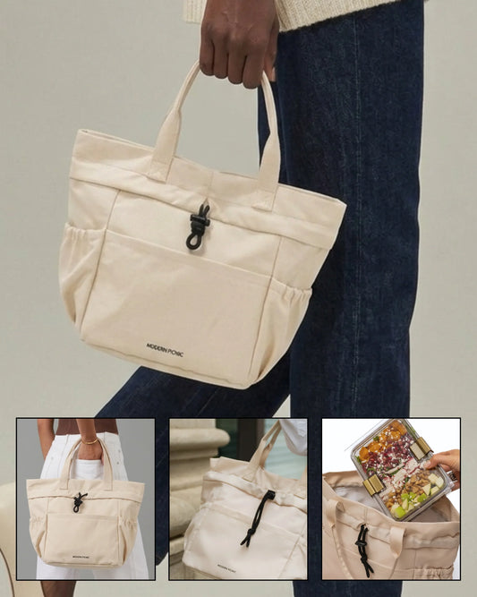Cream vegan leather insulated tote bag being held by a person wearing blue jeans.
