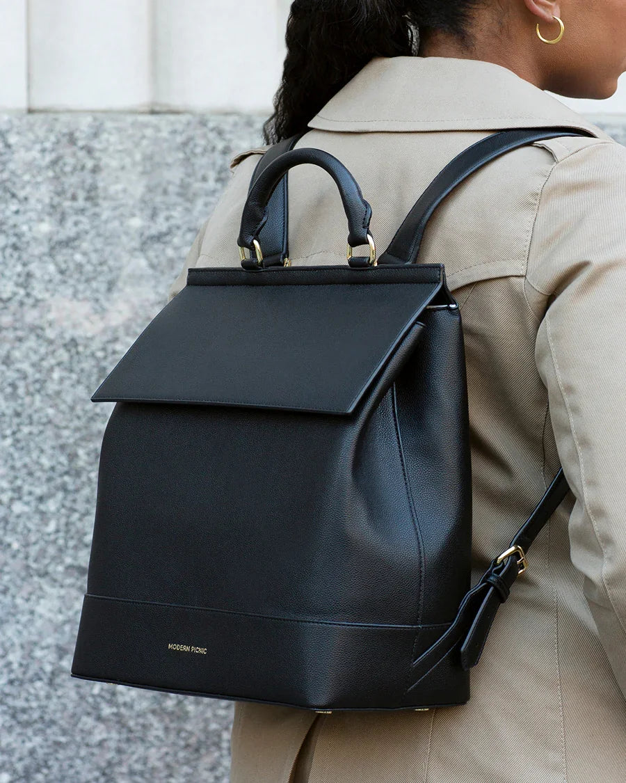 Stylish black vegan leather backpack with gold accents, perfect for work or travel