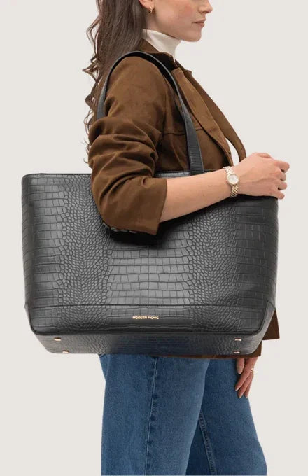 Woman carrying a black croc-embossed vegan leather insulated tote bag