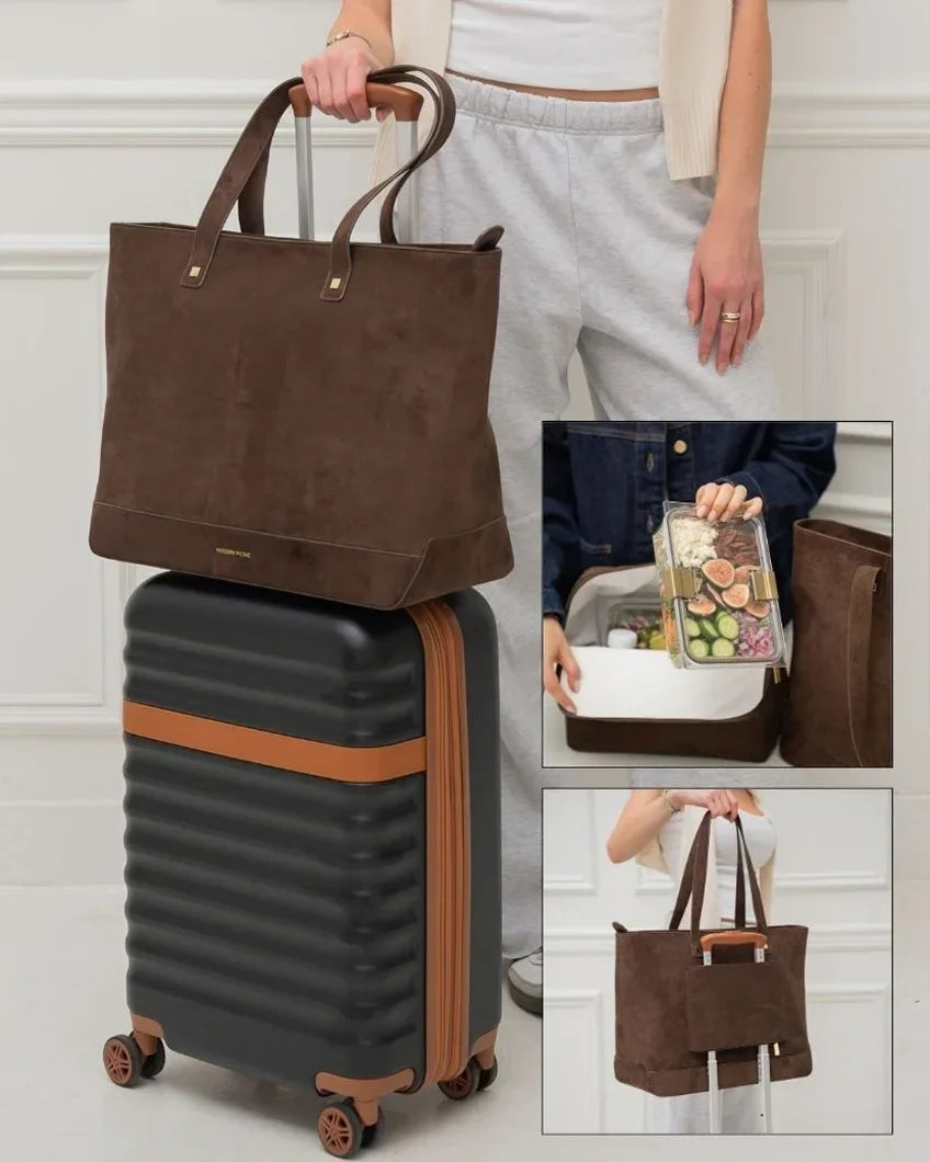 Brown insulated vegan leather tote bag on suitcase, open to show lunch container inside