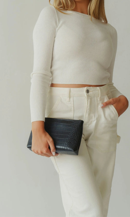 Model holding the Modern Picnic black croc-embossed pouch from THE ORIGINALS SET, styled as a sleek clutch.