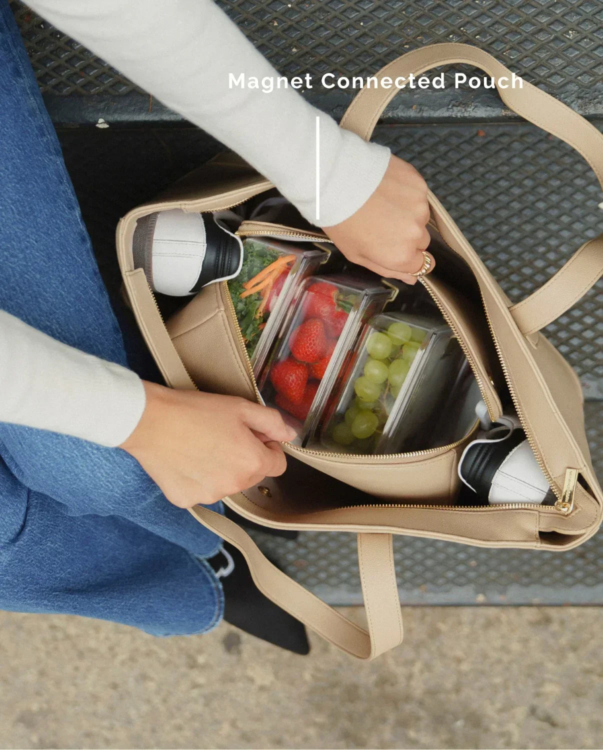 Woman opening Modern Picnic tote in cream vegan leather to access insulated magnetic pouch inside.