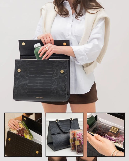 Stylish black insulated lunch bag with vegan leather, holding healthy meals and a green juice bottle.